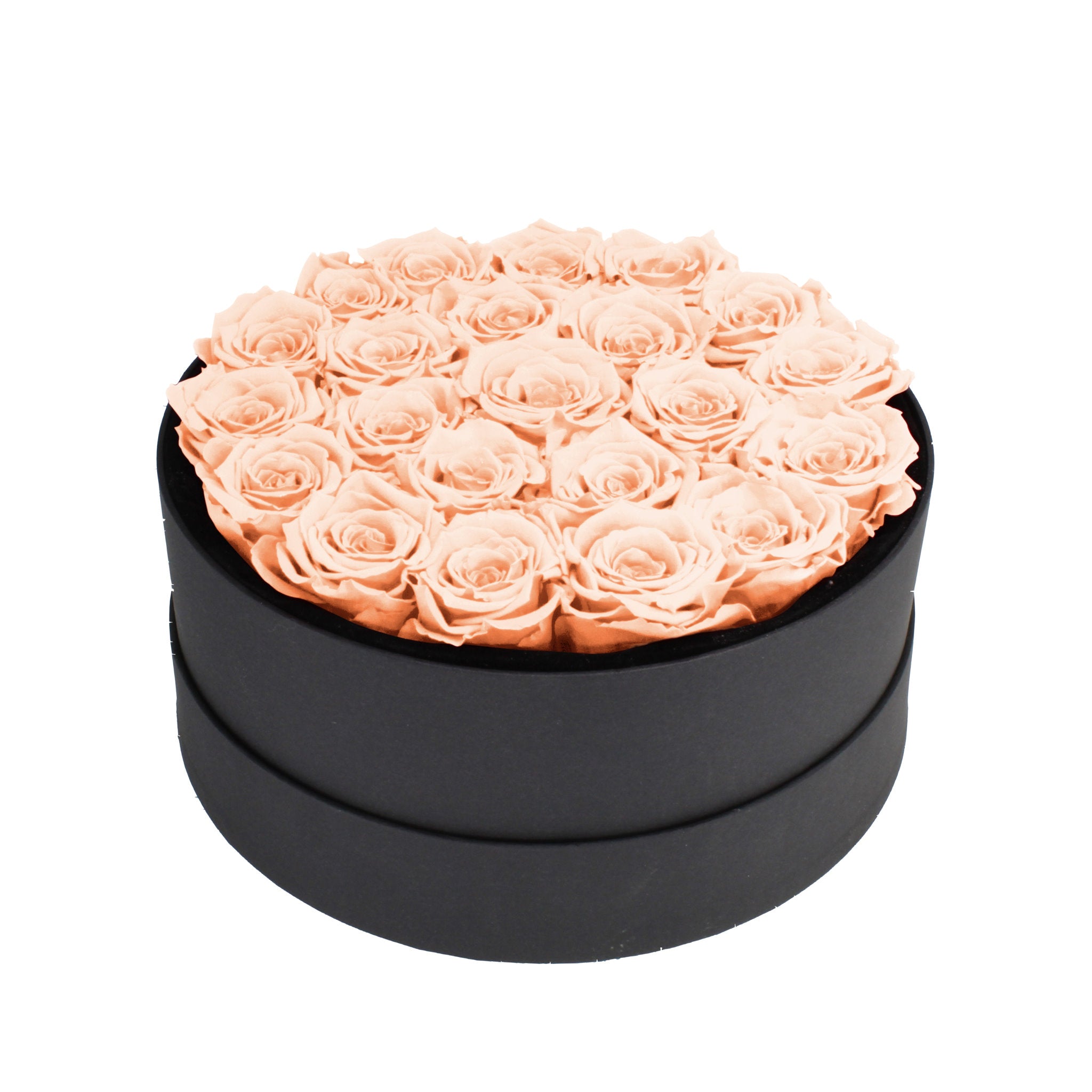 Black round box filled with peach roses on a white background