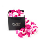 Black 'Only Roses' bag filled with pink and white rose petals on a white background