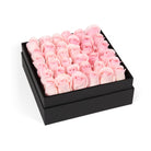 Black box filled with pink roses on a white background