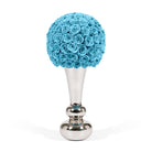Blue rose ball on a silver stand against a white background