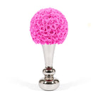 Decorative object with pink rose ball on a silver base against a white background