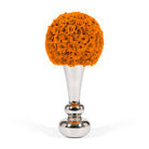 Silver vase with a large ball of orange roses on a white background