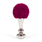 Decorative object with pink rose ball on a silver stand against a white background
