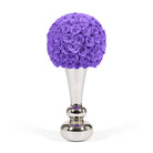 Purple floral arrangement on a silver stand against a white background