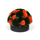 Round arrangement of green and orange roses in a black box on a white background