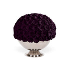 Decorative sphere made of purple roses on a white pedestal against a white background