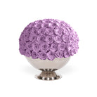 Spherical arrangement of purple roses on a white pedestal against a white background