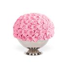 Bouquet of pink roses in a decorative container on a white background