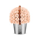 Bouquet of peach roses in a silver metal container with a brown handle on a white background