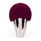 Silver vase with a large bouquet of purple roses on a white background