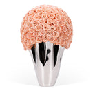 Silver vase with a large ball of peach roses on a white background