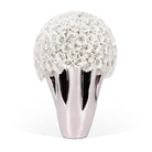 Decorative vase with white rose-like flowers and a metallic base on a white background