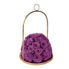 Purple roses in a gold holder on a white background