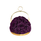 Purple roses in a gold holder on a white background