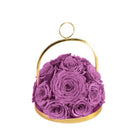 Purple roses in a gold container on a white background