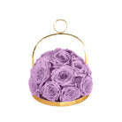 Purple roses in a gold metal holder on a white background