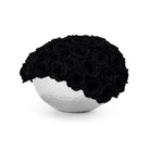 White spherical vase with black roses on a white background