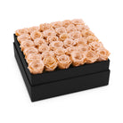 Black box filled with peach roses on a white background