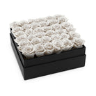 Black box filled with white roses on a white background