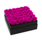 Black box filled with pink roses on a white background