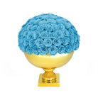 Blue roses on a gold spherical base against a white background