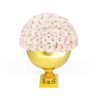 Decorative vase with pink roses on a gold base against a white background