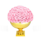 Pink rose ball on a gold pedestal against a white background