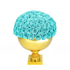 Gold vase with turquoise roses on a white background