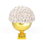 Decorative object with white rose ball on a gold pedestal against a white background