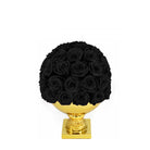 Black roses arranged in a spherical shape on a gold pedestal against a white background