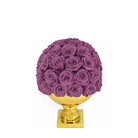 Purple rose ball on a gold pedestal against a white background