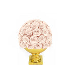 Decorative sphere made of pink roses on a gold stand against a white background