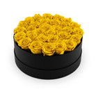 Round black box filled with yellow roses on a white background