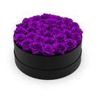 Heart-shaped box filled with purple roses on a white background