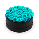 Heart-shaped box filled with turquoise roses on a white background