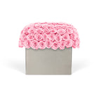 Pink rose arrangement in a gray box on a white background