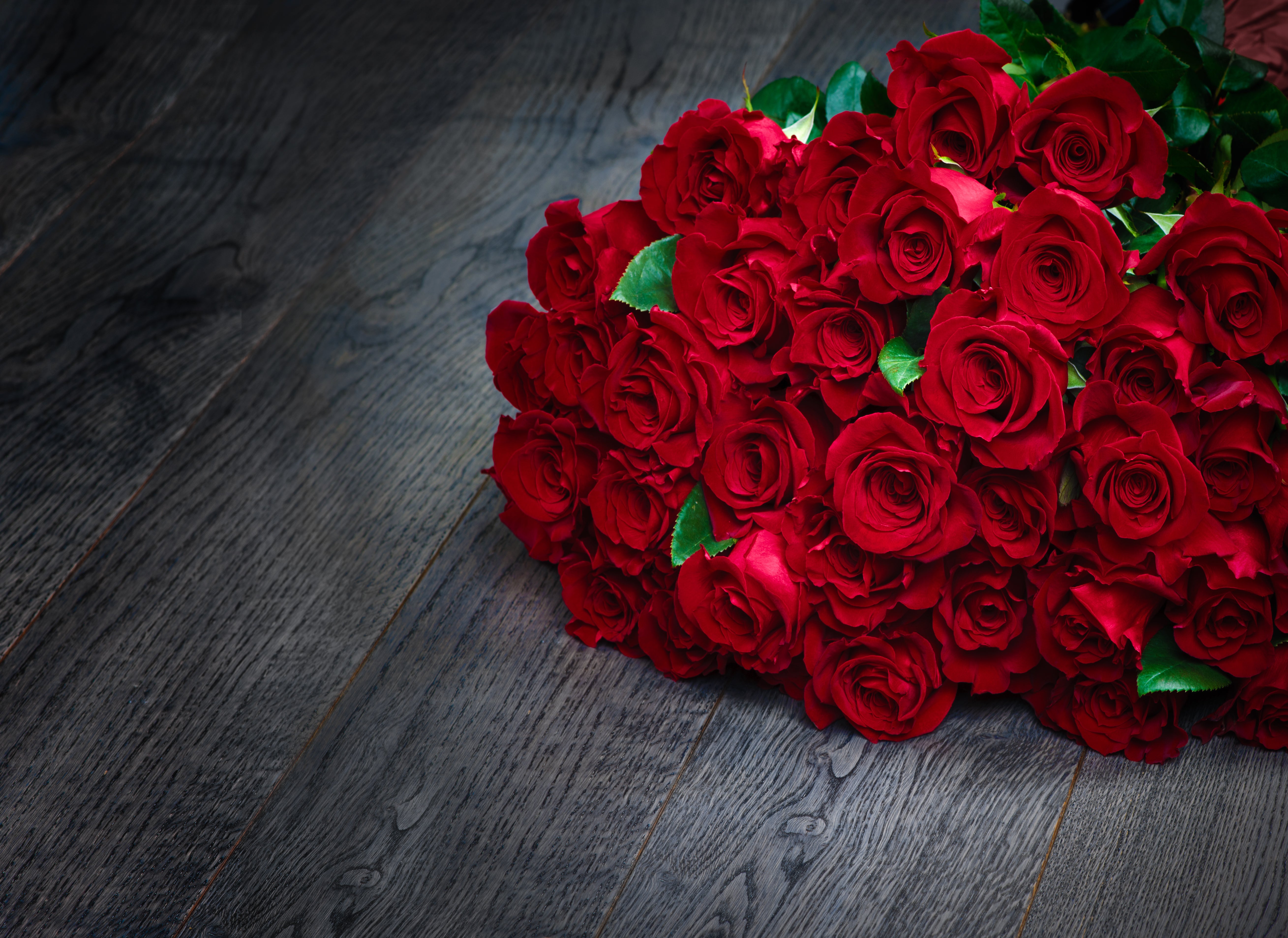 Bouquet of red roses on a dark wooden surface